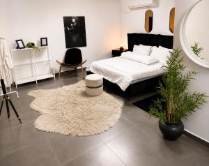 a bedroom with a white bed and a large mirror at סוויטת רגעים Regaim צימר בוטיק בגליל העליון in Sede Eli‘ezer +25 photos