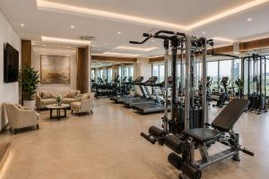 a gym with a row of treadmills and ellipticals at Hotel Park Green Suites Delhi Airport in New Delhi