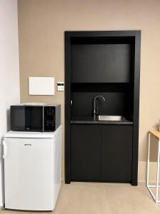 a kitchen with a microwave on top of a refrigerator at MP Luxury room in Budoni