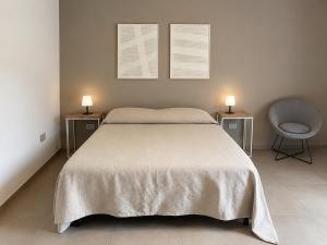 a bedroom with a bed and a chair and two lamps at MP Luxury room in Budoni