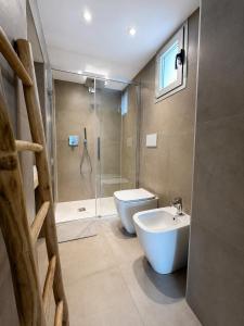 a bathroom with a shower and a toilet and a sink at MP Luxury room in Budoni +11 photos