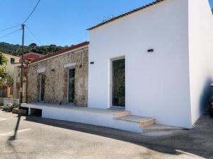 a white building with a bench on the side of it at MP Luxury room in Budoni