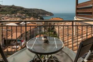 a cat sitting on a glass table on a balcony at Meublé Leonetti in Palinuro