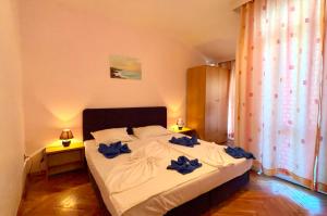 a bedroom with a bed with blue bows on it at Къща за гости ДИАМАНТ in Primorsko +16 photos