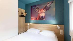 a bedroom with a picture of a deer on the wall at Kyriad ECO - Dijon Sud Chenove in Chenôve