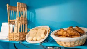 a table with baskets of bread and pastries on it at Kyriad ECO - Dijon Sud Chenove in Chenôve