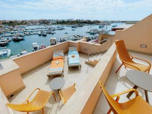 a balcony with chairs and tables and a harbor at Best Western Hotel Martello in Lampedusa