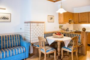 a living room with a table and a couch and a kitchen at NaturResidence Dolomitenhof in Siusi