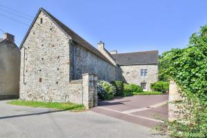 an old stone building with a road in front of it at Manoir De Labelangerie in Acqueville