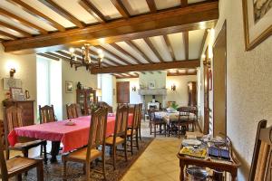 a dining room with a red table and chairs at Manoir De Labelangerie in Acqueville