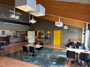 a lobby with tables and chairs and a yellow door at Overhalla Hotel in Overhalla  +39 photos