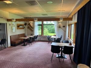 a waiting room with tables and chairs and windows at Overhalla Hotel in Overhalla 