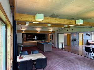 a room with tables and chairs and a kitchen at Overhalla Hotel in Overhalla 