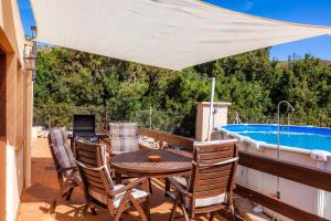 a patio with a table and chairs and a pool at Apartment Tina Capdepera in Capdepera