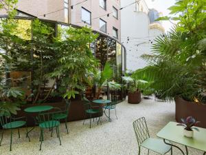 a patio with tables and chairs and plants at ibis Brussels Centre Chatelain in Brussels