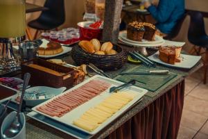 a table with a buffet of food on a table at Hotel Colonial Bragança Paulista in Bragança Paulista
