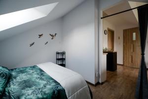 a bedroom with a bed with birds on the wall at VISTA Necko - apartament nad jeziorem Augustów in Augustów