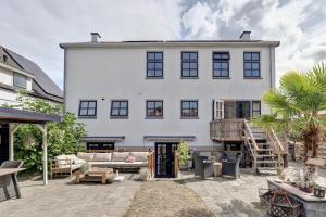 a large white house with a patio in front of it at By Onzz in Kamperland