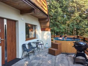 a patio with a hot tub and a table and chairs at Domek Chatka Czubatka in Bocheniec +18 photos