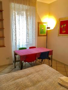 ローマにあるModì Apartmentのテーブルと椅子4脚、窓が備わる客室です。