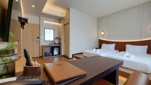 a hotel room with two beds and a desk at Marwin Villa in Bangkok +71 photos