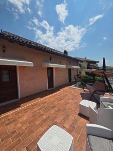 a patio with white furniture and a house at Volo Libero - Guest House in Poggio Bustone