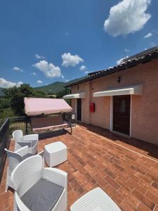 a patio with white chairs and a table and awning at Volo Libero - Guest House in Poggio Bustone