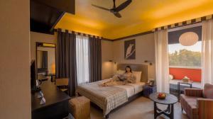 a woman sitting on a bed in a hotel room at The Sierra - By The Lake in Udaipur +75 photos