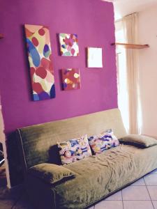 un sofá en una habitación con una pared púrpura en Modì Apartment en Roma