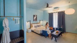 a woman sitting on a bed in a room at The Sierra - By The Lake in Udaipur