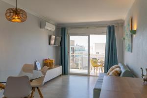 a living room with a table and a dining room at Hotel & Apartaments Thalassa Sport & Wellness in Roses
