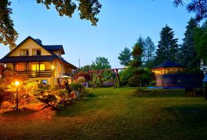 a house with a light on the yard at night at Bieszczady Pod Dębem Solina in Solina