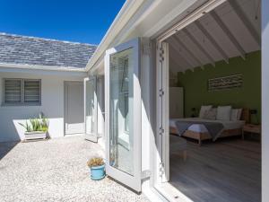 a sliding glass door leading to a patio with a bed at The Barn Style Cottage in Cape Town