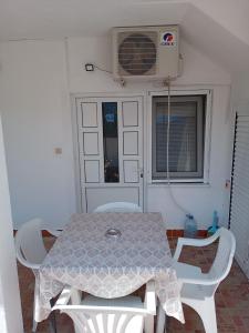a table and chairs in a room with a fan at Vila Ruška in Prčanj