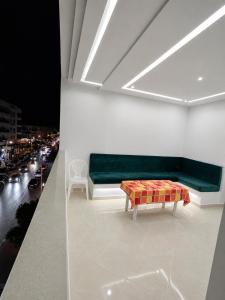 a living room with a green couch and a table at Appartement MIRAMAR in Martil