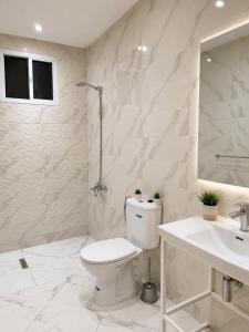 a white bathroom with a toilet and a sink at Appartement MIRAMAR in Martil +35 photos