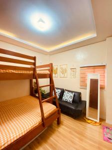 a room with a bunk bed and a couch at Second Pad at Second floor in Bolinao