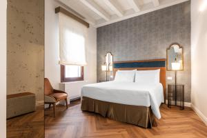 a bedroom with a large white bed and a chair at Ca' Del Campo in Venice