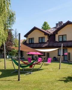 a group of chairs and umbrellas in front of a house at Rafa in Rowy