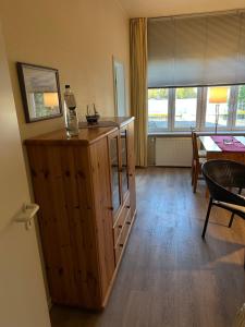 a room with a wooden cabinet with a bottle on top at Landhaus Gerdts - 2 in Cuxhaven