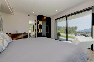 a bedroom with a white bed and a large window at Villa Casara Design and Relax Lago di Garda in Costermano +49 photos