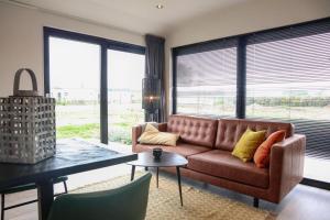 a living room with a couch and a table at Cube la Mer 4 in Olburgen