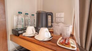 a counter with a coffee maker and dishes on it at Baanna Place in Ban Na