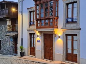 a building with wooden doors and windows on a street at Casona El Gurugu in Luarca