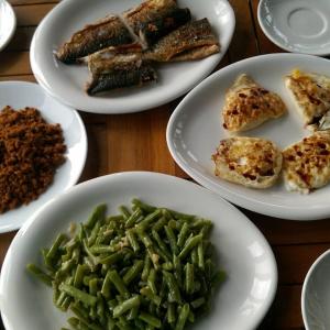 einen Tisch mit Teller mit Lebensmitteln und grünen Bohnen in der Unterkunft Sung-Ding Guesthouse in Jian