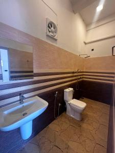 a bathroom with a sink and a toilet at Surf and stay A- Bay in Arugam Bay