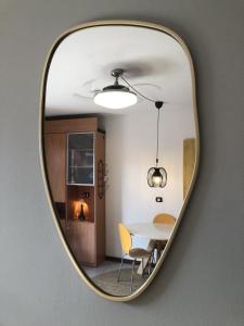 Ein Spiegel reflektiert ein Esszimmer mit Tisch und Stühlen. in der Unterkunft Camelia 07 in Acquaseria