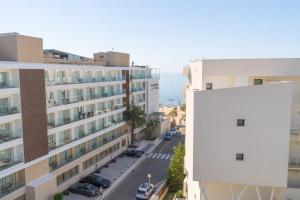 an aerial view of a building with the ocean in the background at Hotel & Apartaments Thalassa Sport & Wellness in Roses