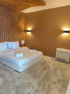 a bedroom with a large bed and a brick wall at Deluxe House Glavatarski Han in Glavatartsi
