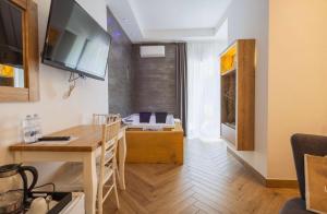 ein Wohnzimmer mit einem Tisch und einem Fernseher an der Wand in der Unterkunft Suite Pizzo jacuzzi rooms in Pizzo